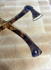 Large end-grain maple butcher block with a custom dark wood double axe inlay