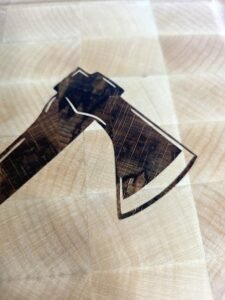Large end-grain maple butcher block with a custom dark wood double axe inlay