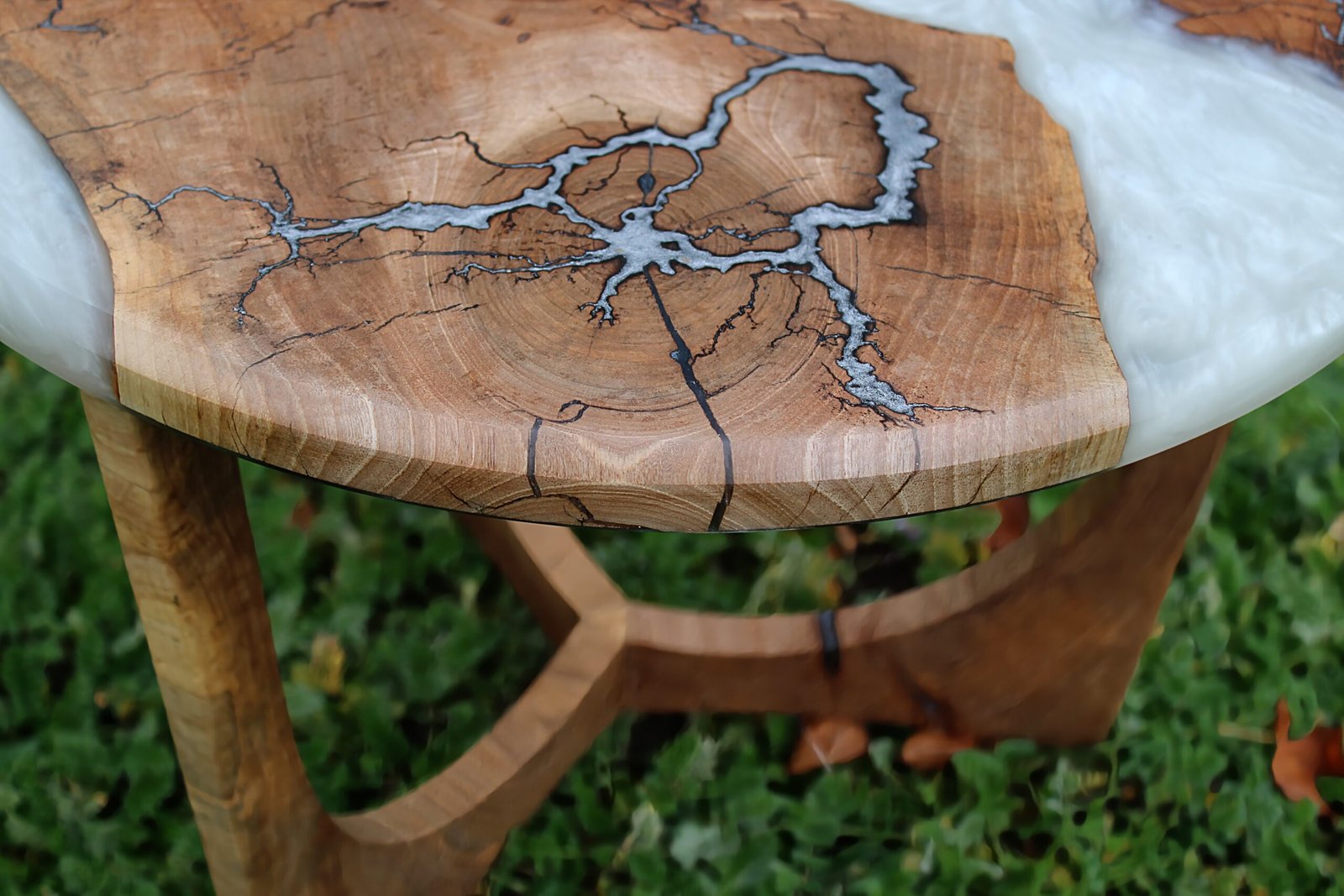 IMG_2254 - M & B CRAFT A round handcrafted walnut wood coffee table featuring a metallic pearl resin river running through the center, detailed with silver-inlaid Lichtenberg fractal lightning patterns on a custom sculpted wooden base,