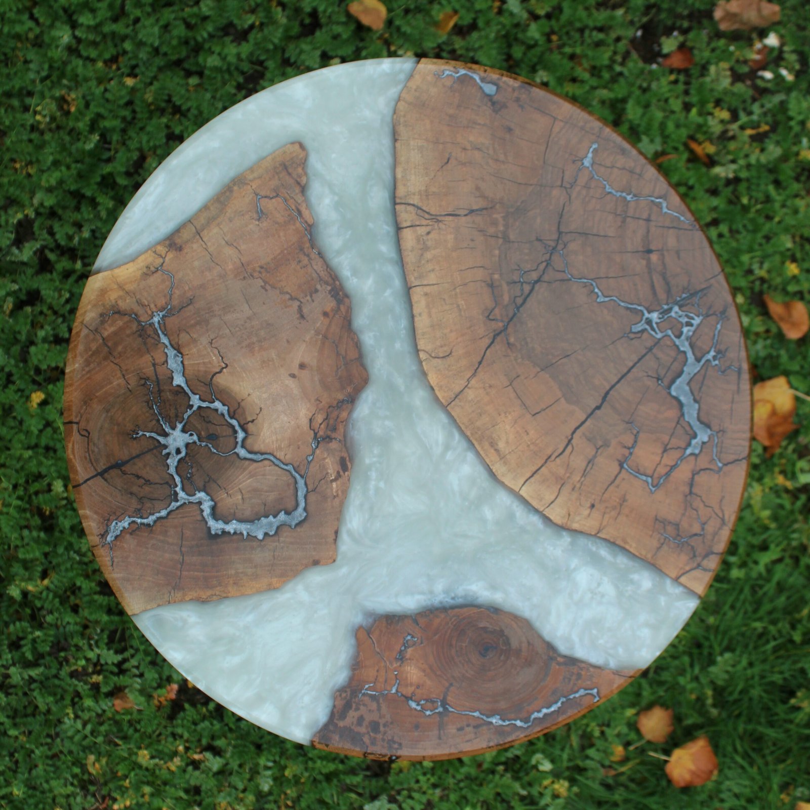 IMG_2257 - M & B CRAFT A round handcrafted walnut wood coffee table featuring a metallic pearl resin river running through the center, detailed with silver-inlaid Lichtenberg fractal lightning patterns on a custom sculpted wooden base,