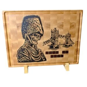 Wooden cutting board with a black engraved skeleton in uniform and a castle, plus the text 'DEAD ON DUTY'.