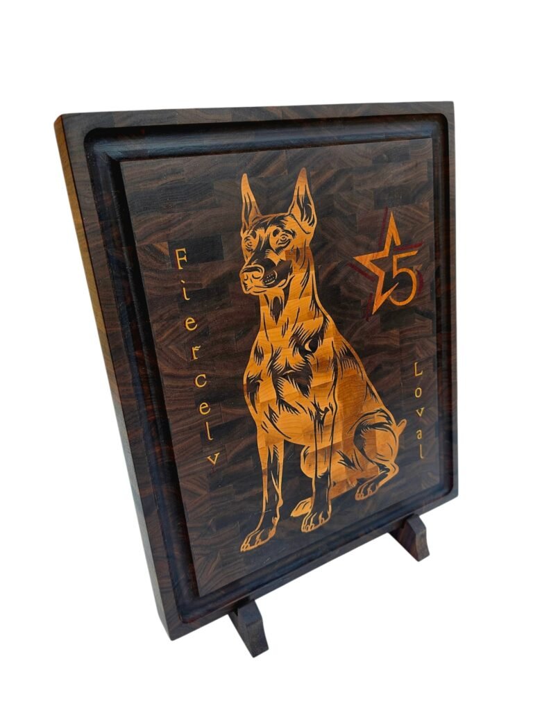 Handmade walnut end grain cutting board with detailed maple and padauk Doberman dog inlay on a display stand.