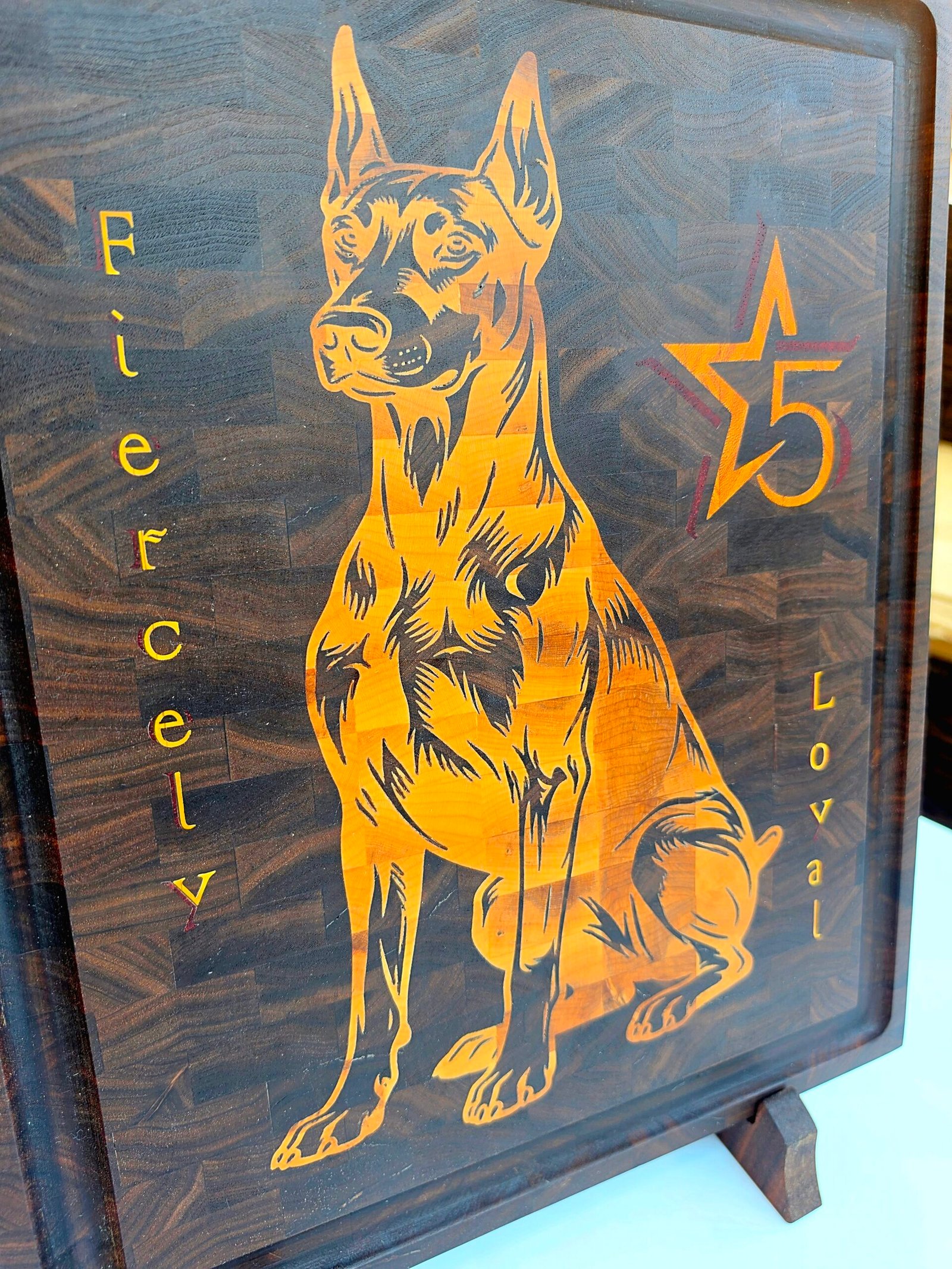 20260708_141648 - M & B CRAFT Handmade walnut end grain cutting board with detailed maple and padauk Doberman dog inlay on a display stand.