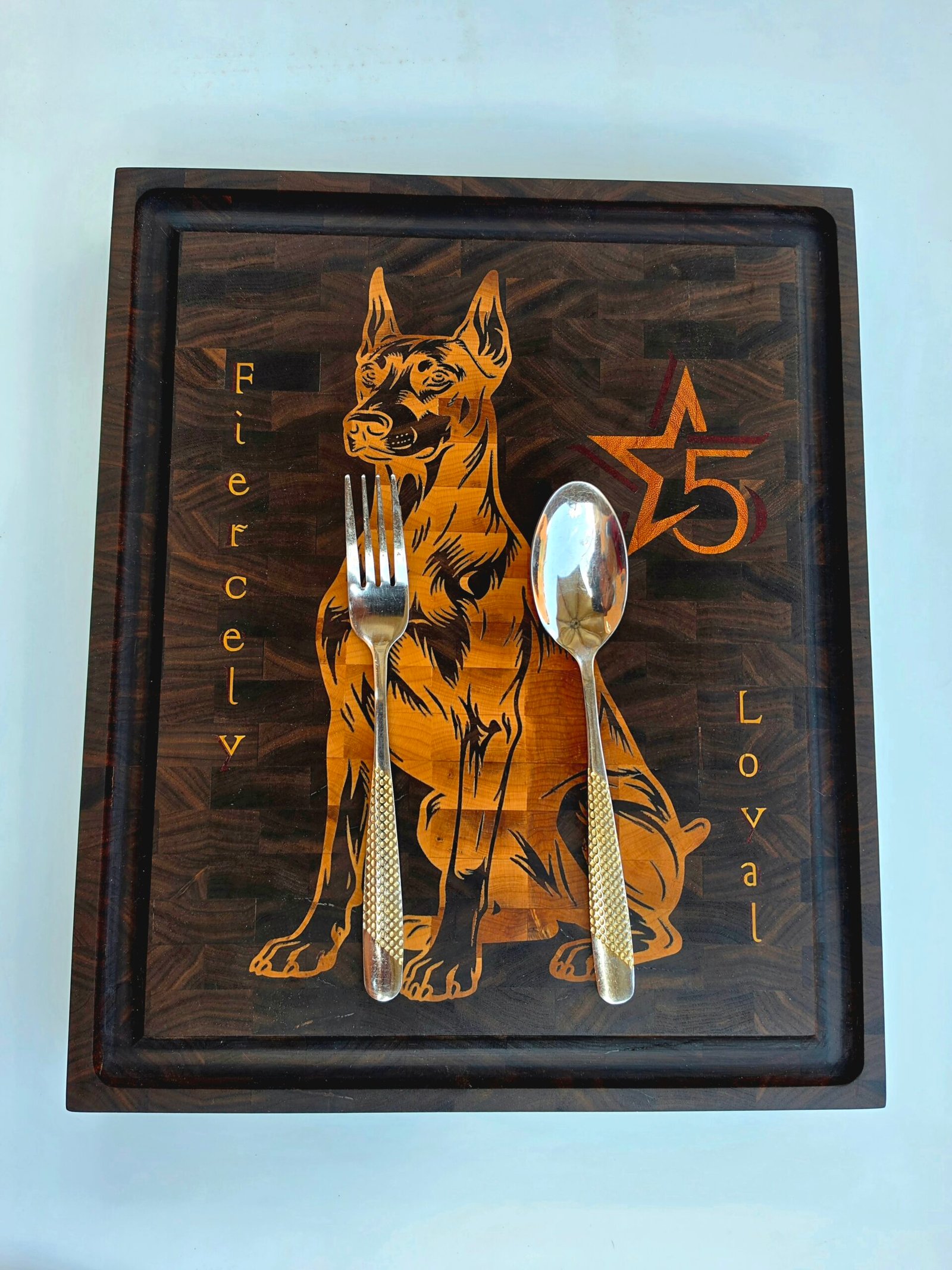 20260708_141823 - M & B CRAFT Handmade walnut end grain cutting board with detailed maple and padauk Doberman dog inlay on a display stand.